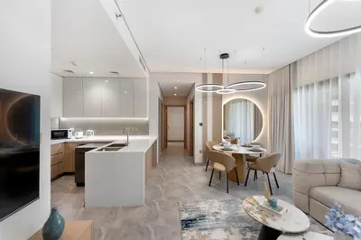 a kitchen and living room with a couch and a table at Brand New 2BR Peninsula One with Burj Khalifa View in Dubai
