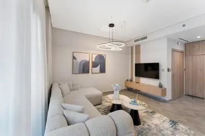 a living room with a couch and a tv at Brand New 2BR Peninsula One with Burj Khalifa View in Dubai