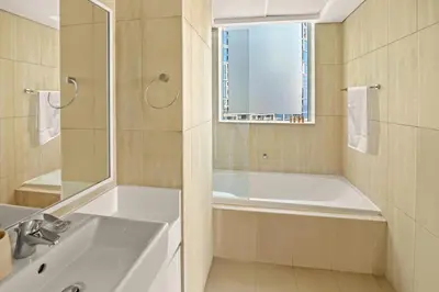 a bathroom with a tub and a sink and a window at 1st Row Beach Views with Private Beach and Resort Vibes in Dubai