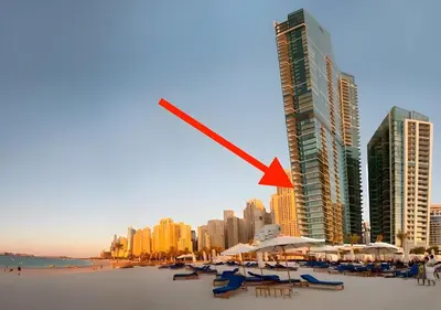 a view of a beach with chairs and buildings at 1st Row Beach Views with Private Beach and Resort Vibes in Dubai