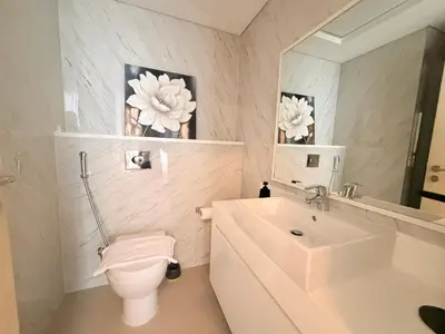 a bathroom with a sink and a toilet and a mirror at Beachfront Luxury Penthouse at The Walk JBR next to Bluewaters Island - 2BR & Maids Room in Dubai