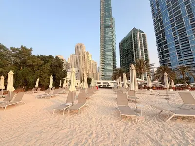 a bunch of chairs and umbrellas on a beach at Beachfront Luxury Penthouse at The Walk JBR next to Bluewaters Island - 2BR & Maids Room in Dubai
