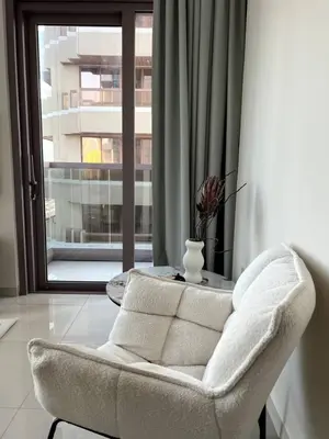 a white chair in a room with a window at Amazing 1BR Full Burj View in Dubai
