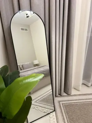 a mirror in a living room with a curtain at Amazing 1BR Full Burj View in Dubai