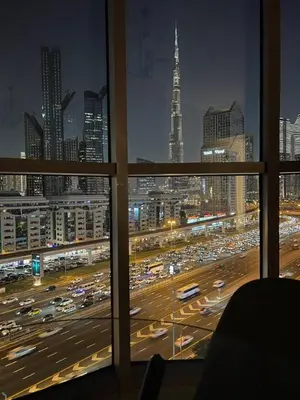 a view of a busy city at night from a window at Amazing 1BR Full Burj View in Dubai