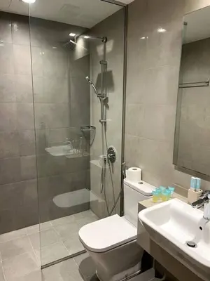 a bathroom with a shower and a toilet and a sink at Amazing 1BR Full Burj View in Dubai