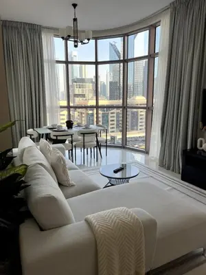 a living room with a white couch and a large window at Amazing 1BR Full Burj View in Dubai