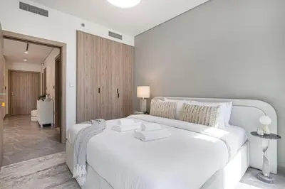 a white bedroom with a large white bed in it at StayMada - Peninsula Panoramic Waterfront Views in Dubai
