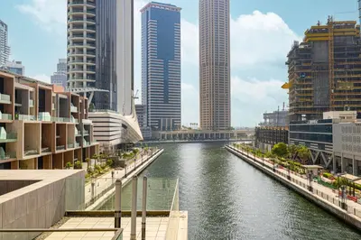a river in a city with tall buildings at StayMada - Peninsula Waterfront and Pool Views in Dubai