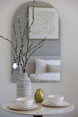 a table with two plates and a vase with flowers at StayMada - Peninsula Waterfront and Pool Views in Dubai