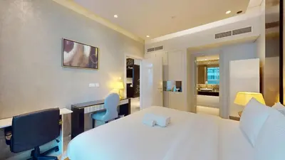 a bedroom with a white bed and a desk and chairs at Vacationer l Stylish 1 Bedroom l Downtown Dubai l Pool, Gym Access in Dubai