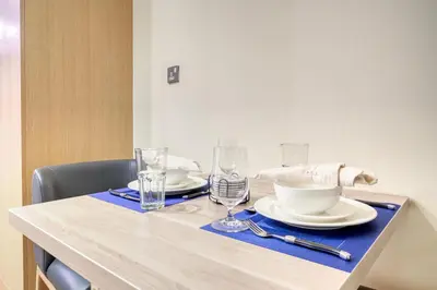 a table with plates and glasses on top of it at Vacationer I Upgraded Studio I Heart of JBR I Near JBR Beach, Cafes & Restaurants in Dubai