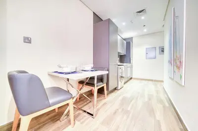 a kitchen with a table and chairs in a room at Vacationer I Upgraded Studio I Heart of JBR I Near JBR Beach, Cafes & Restaurants in Dubai
