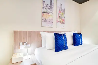 a bedroom with a white bed with blue pillows at Vacationer I Upgraded Studio I Heart of JBR I Near JBR Beach, Cafes & Restaurants in Dubai