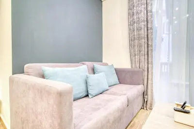 a living room with a couch with blue pillows at Vacationer I Upgraded Studio I Heart of JBR I Near JBR Beach, Cafes & Restaurants in Dubai