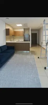 a living room with a blue couch and a kitchen at Accommodation for girls only in Dubai