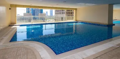a large swimming pool in a building with a large window at Accommodation for girls only in Dubai