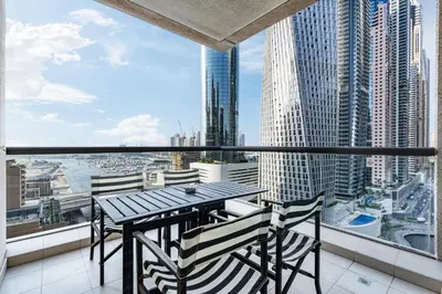 a balcony with a table and chairs and a view of a city at Exquisite Marina Home with Panoramic Yacht Views in Dubai
