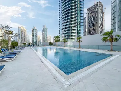 a large swimming pool in a city with tall buildings at Exquisite Marina Home with Panoramic Yacht Views in Dubai