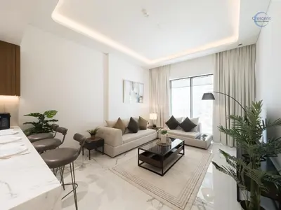 a living room with a couch and a table at Modern Retreat at Azizi Azure, Meydan in Dubai