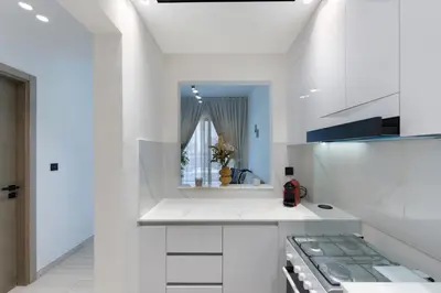 a white kitchen with white cabinets and a stove at Elegant 1BR Stay in Binghatti Heights JVC in Dubai