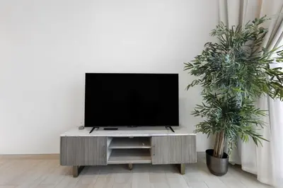 a flat screen tv sitting on top of a entertainment center at Elegant 1BR Stay in Binghatti Heights JVC in Dubai