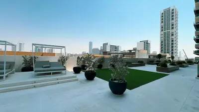 a patio with chairs and potted plants on a building at Elegant 1BR Stay in Binghatti Heights JVC in Dubai