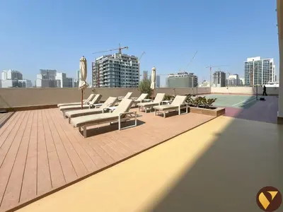 a row of lounge chairs on the roof of a building at Vogue JVC Jeewar Tower near Circle Mall, Two Bedroom Apartment with Balcony and City View, Access to all Amenities in Dubai