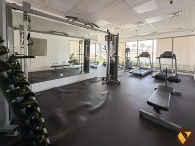 a gym with a bunch of treadmills and mirrors at Vogue JVC Jeewar Tower near Circle Mall, Two Bedroom Apartment with Balcony and City View, Access to all Amenities in Dubai