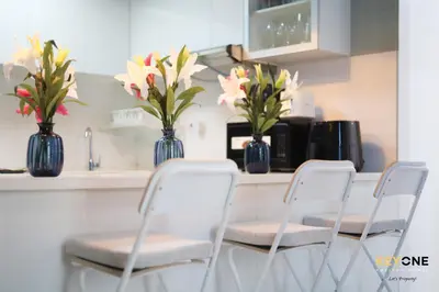 a table with four chairs and vases with flowers in them at Serene Beachside Two-Bedroom Retreat in Dubai