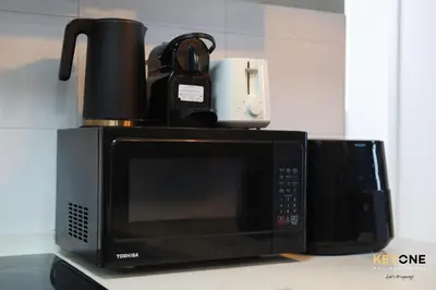 a microwave with a coffee pot on top of it at Serene Beachside Two-Bedroom Retreat in Dubai