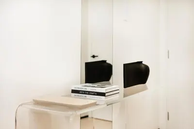a white table with a laptop and books on it at Opera Grand Sky Luxurious 3-Bedroom Apartment in Downtown Dubai with Panoramic Burj Khalifa View in Dubai