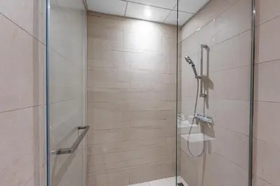 a shower with a glass door in a bathroom at Bright Designer Stay in Luxurious Comfort in Dubai