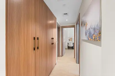 a hallway with wooden cabinets and a hallway leading into a house at Bright Designer Stay in Luxurious Comfort in Dubai