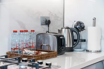 a kitchen counter with a toaster and bottles of water at Bright Designer Stay in Luxurious Comfort in Dubai