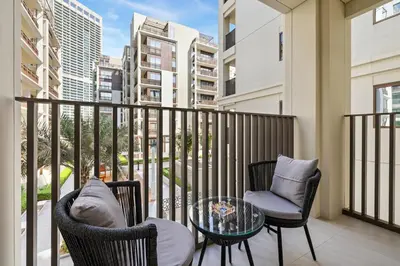 a balcony with two chairs and a glass table at Creek Beach Sunset 3! Lagoon Access! in Dubai