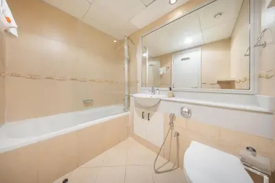 a bathroom with a tub and a sink and a mirror at StayShort - Sophisticated unit in JLT Sleeps 6 with Lake Views in Dubai