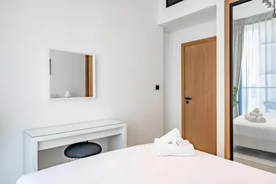 a bedroom with a bed and a mirror and a fireplace at Homes Beyond l 1BR Cozy Modern Escape in JVC in Dubai