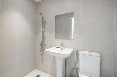 a white bathroom with a sink and a toilet at 2 Bedroom Bluewaters Retreat with Office and Pool Views in Dubai