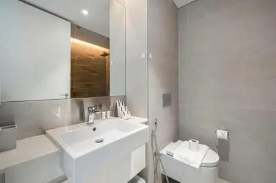 a bathroom with a sink and a toilet and a mirror at 2 Bedroom Bluewaters Retreat with Office and Pool Views in Dubai