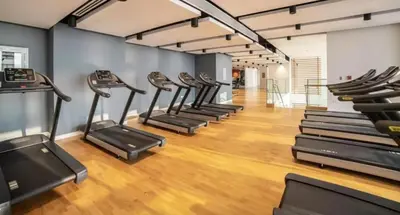 a row of cardio machines in a gym at Luxury 2 Bedroom Apartment with Maids Room and Large Terrace in Dubai