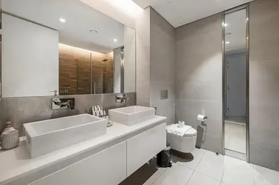 a white bathroom with a sink and a toilet at Luxury 2 Bedroom Apartment with Maids Room and Large Terrace in Dubai