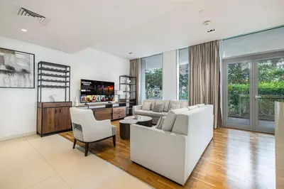 a living room with a white couch and chairs at Luxury 2 Bedroom Apartment with Maids Room and Large Terrace in Dubai