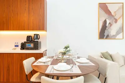 a dining room with a table with white chairs at PVH - Breezy 1BR with Partial Sea View - La Sirene in Dubai
