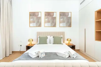 a white bedroom with a large bed with two pillows at PVH - Breezy 1BR with Partial Sea View - La Sirene in Dubai
