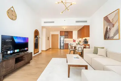a living room with a couch and a tv at PVH - Breezy 1BR with Partial Sea View - La Sirene in Dubai