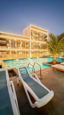 a hotel with a swimming pool with a slide at Chic 1BR Retreat with Infinity Pool and Sauna in JVC, Dubai in Dubai