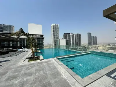 a large swimming pool on top of a building at Chic 1BR Retreat with Infinity Pool and Sauna in JVC, Dubai in Dubai