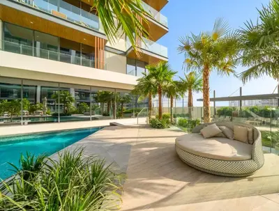 a resort with a swimming pool and a wicker couch next to a building at Stylish Dubai Hills Studio with Rooftop Pool and Gym in Dubai