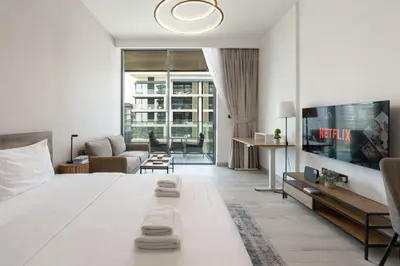 a living room with a large bed and a couch at Stylish Dubai Hills Studio with Rooftop Pool and Gym in Dubai